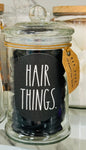 New Rae Dunn glass storage jar filled with HAIR THINGS.